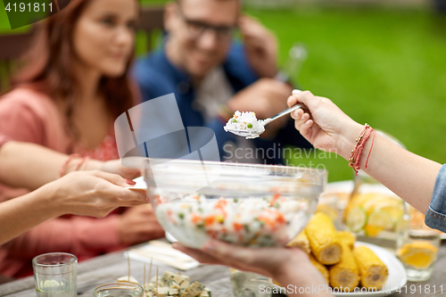 Image of happy friends having dinner at summer garden party