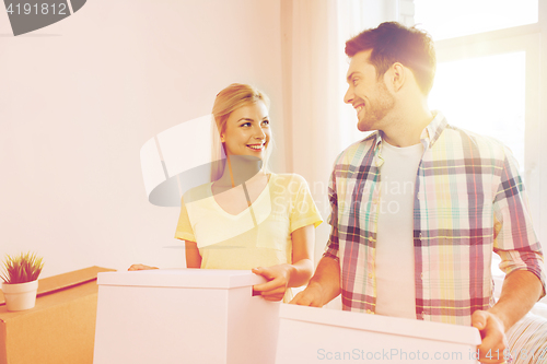 Image of smiling couple with big boxes moving to new home