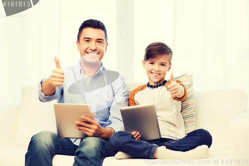 Image of father and son with tablet pc showing thumbs up