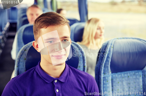 Image of happy young man sitting in travel bus or train