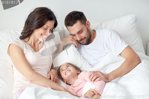 Image of happy family in bed at home