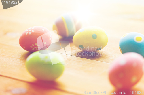 Image of close up of colored easter eggs on wooden surface