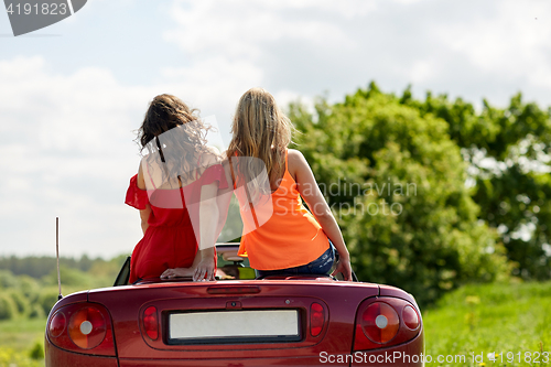 Image of friends driving in convertible car at summer 