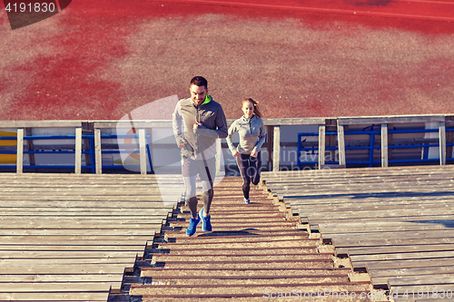 Image of happy couple running upstairs on stadium