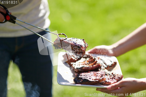 Image of man cooking meat at summer party barbecue