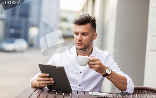 Image of man with tablet pc and coffee at city cafe