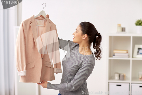 Image of happy woman with jacket at home