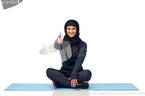 Image of muslim woman doing sport and showing thumbs up