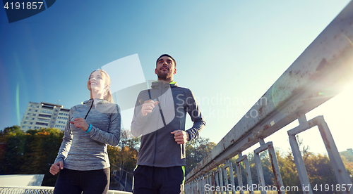 Image of happy couple running outdoors