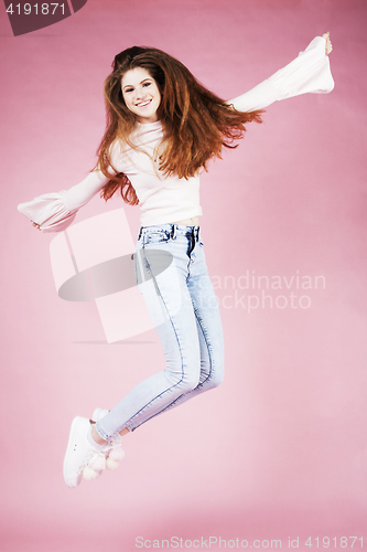 Image of young pretty red hair ginger girl jumping isolated on pink background, lifestyle flying teen people concept close up