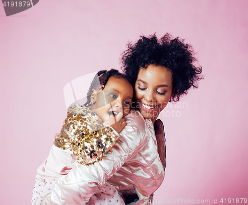 Image of young pretty african-american mother with little cute daughter hugging, happy smiling on pink background, lifestyle modern people concept 