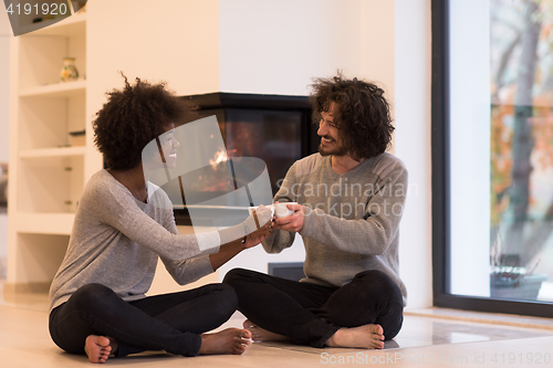 Image of multiethnic couple  in front of fireplace