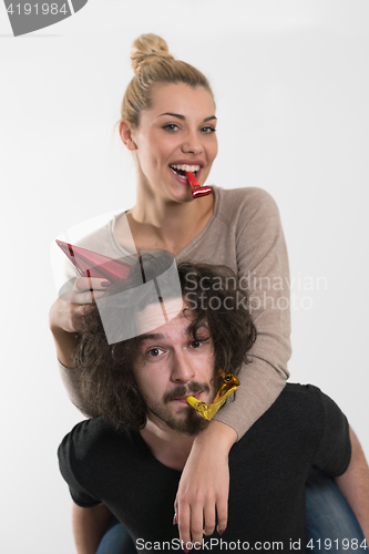 Image of couple in party hats blowing in whistle