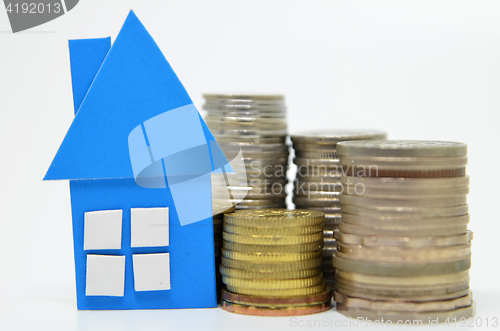 Image of House model and stacks of coins