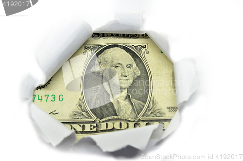 Image of US currency peeking through white paper.