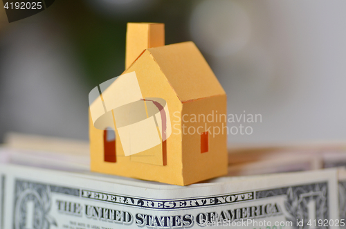 Image of Miniature paper made house stand on  money