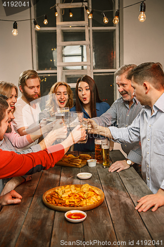 Image of Group of friends enjoying evening drinks with beer