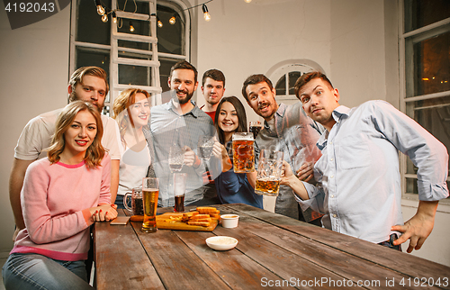 Image of Group of friends enjoying evening drinks with beer