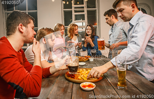 Image of Group of friends enjoying evening drinks with beer