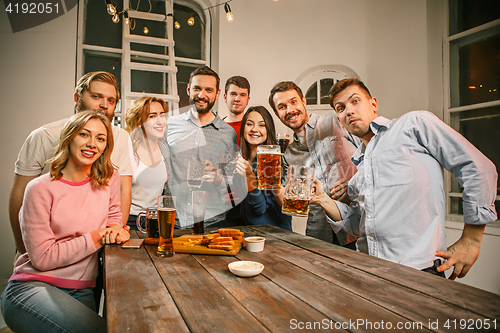 Image of Group of friends enjoying evening drinks with beer