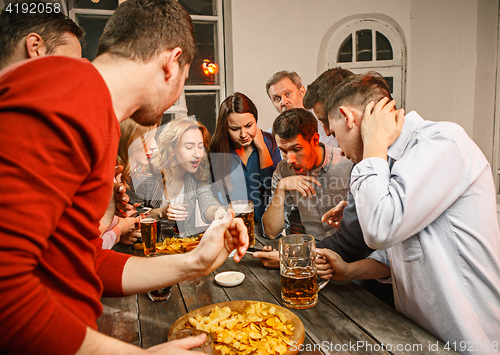 Image of Group of friends enjoying evening drinks with beer