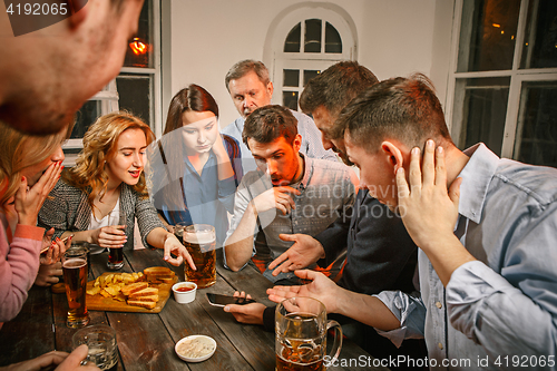 Image of Group of friends enjoying evening drinks with beer