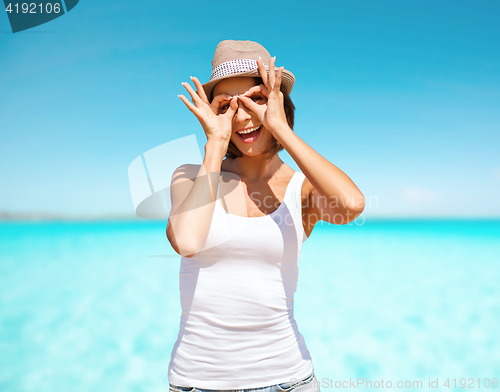 Image of happy young woman in hat over blue sky and sea