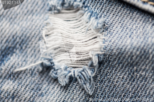 Image of close up of hole on shabby denim or jeans clothes