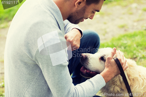 Image of close up of man with labrador dog outdoors