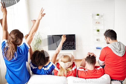 Image of friends or football fans watching tv at home