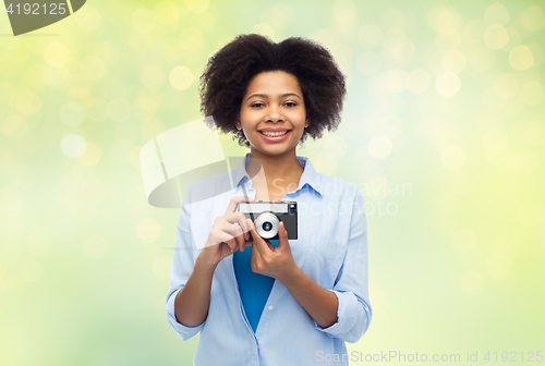 Image of happy african american woman with film camera