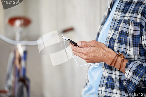 Image of man with earphones and smartphone listening music