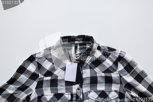 Image of close up of checkered shirt on white background