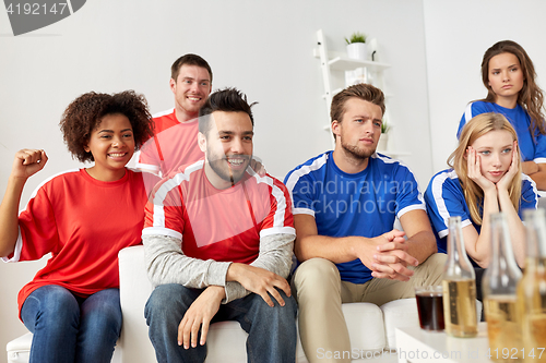 Image of friends or football fans watching soccer at home