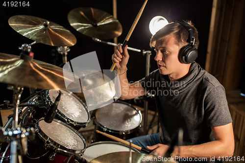 Image of male musician playing drums and cymbals at concert