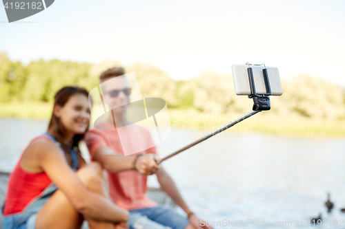 Image of happy teenage couple taking selfie on smartphone