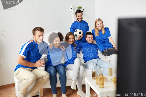 Image of friends or football fans watching soccer at home