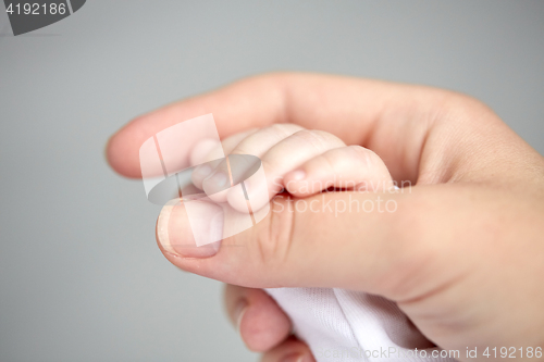 Image of close up of mother and newborn baby hands