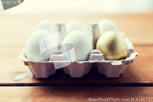 Image of close up of white and gold eggs in egg box