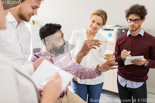 Image of happy business team discussing something at office