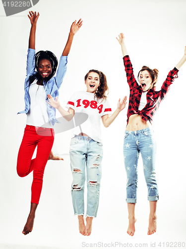 Image of three pretty young diverse nations teenage girl friends jumping happy smiling on white background, lifestyle people concept 