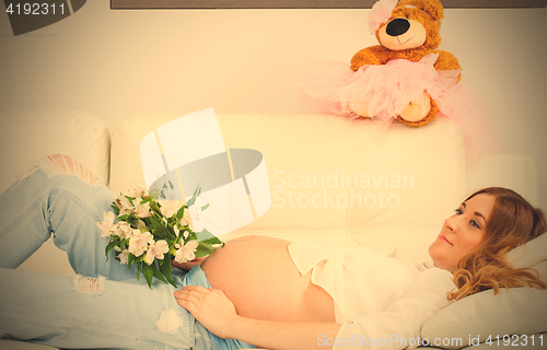 Image of Pregnant woman with a bouquet of flowers