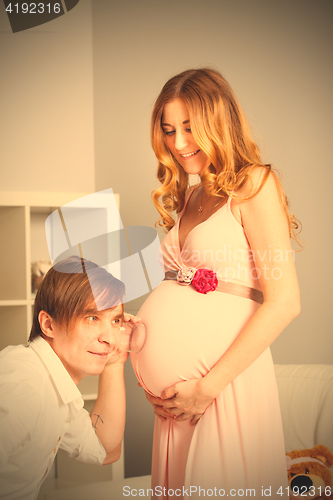 Image of man listening pregnant belly