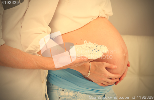 Image of baby booties for the newborn on the palm of his father