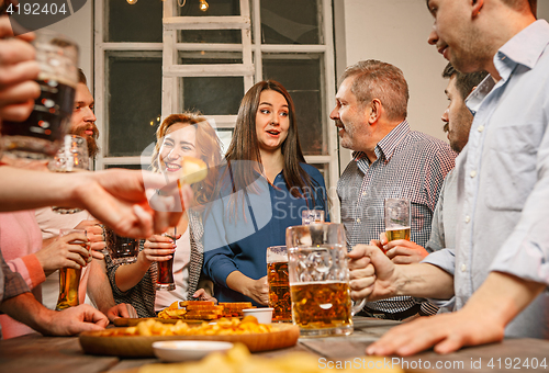 Image of Group of friends enjoying evening drinks with beer