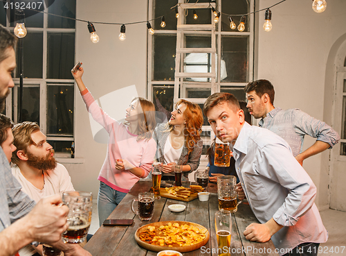 Image of Group of friends enjoying evening drinks with beer