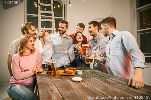 Image of Group of friends enjoying evening drinks with beer