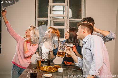 Image of Group of friends enjoying evening drinks with beer