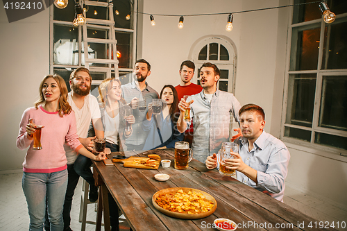 Image of Group of friends enjoying evening drinks with beer