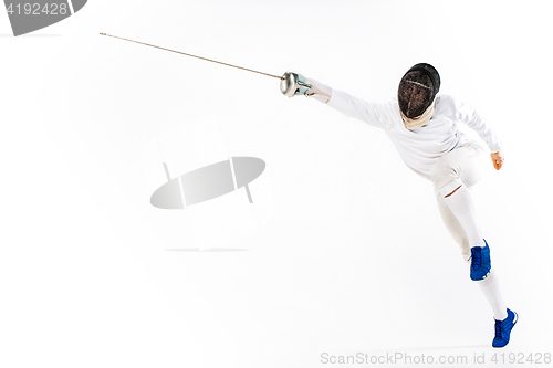 Image of Man wearing fencing suit practicing with sword against gray